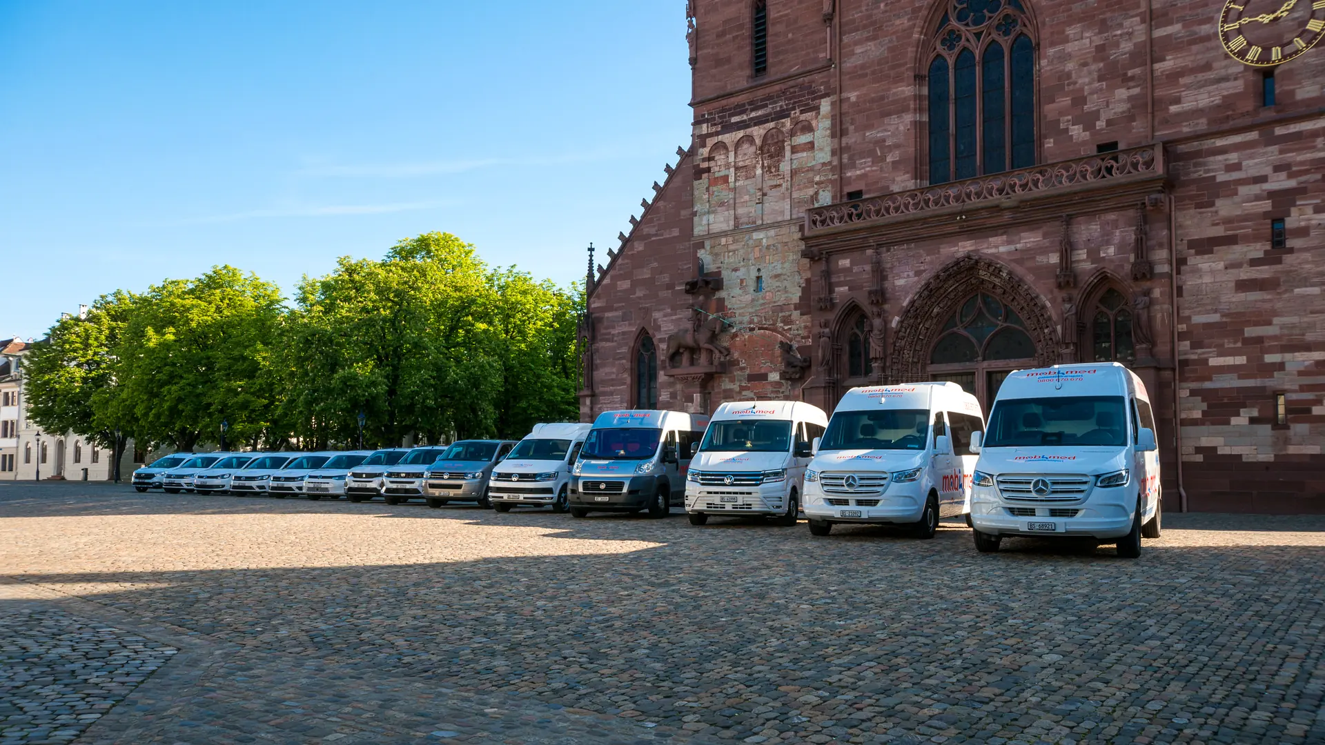 Die Fahrzeugflotte von Mobimed Patiententransport auf dem Münsterplatz in Basel