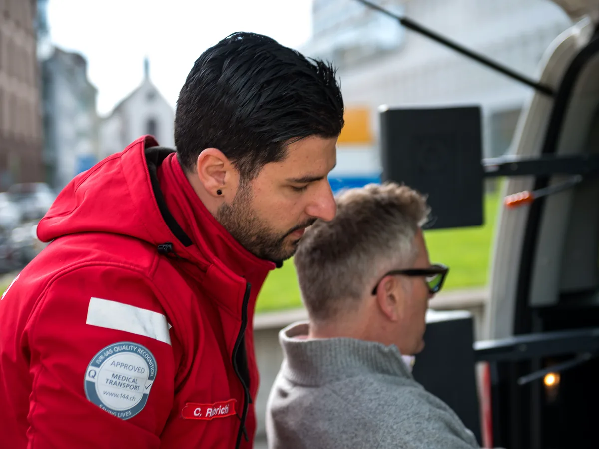 Mitarbeiter von Mobimed spricht mit einem Patienten beim Einsteigen ins Fahrzeug